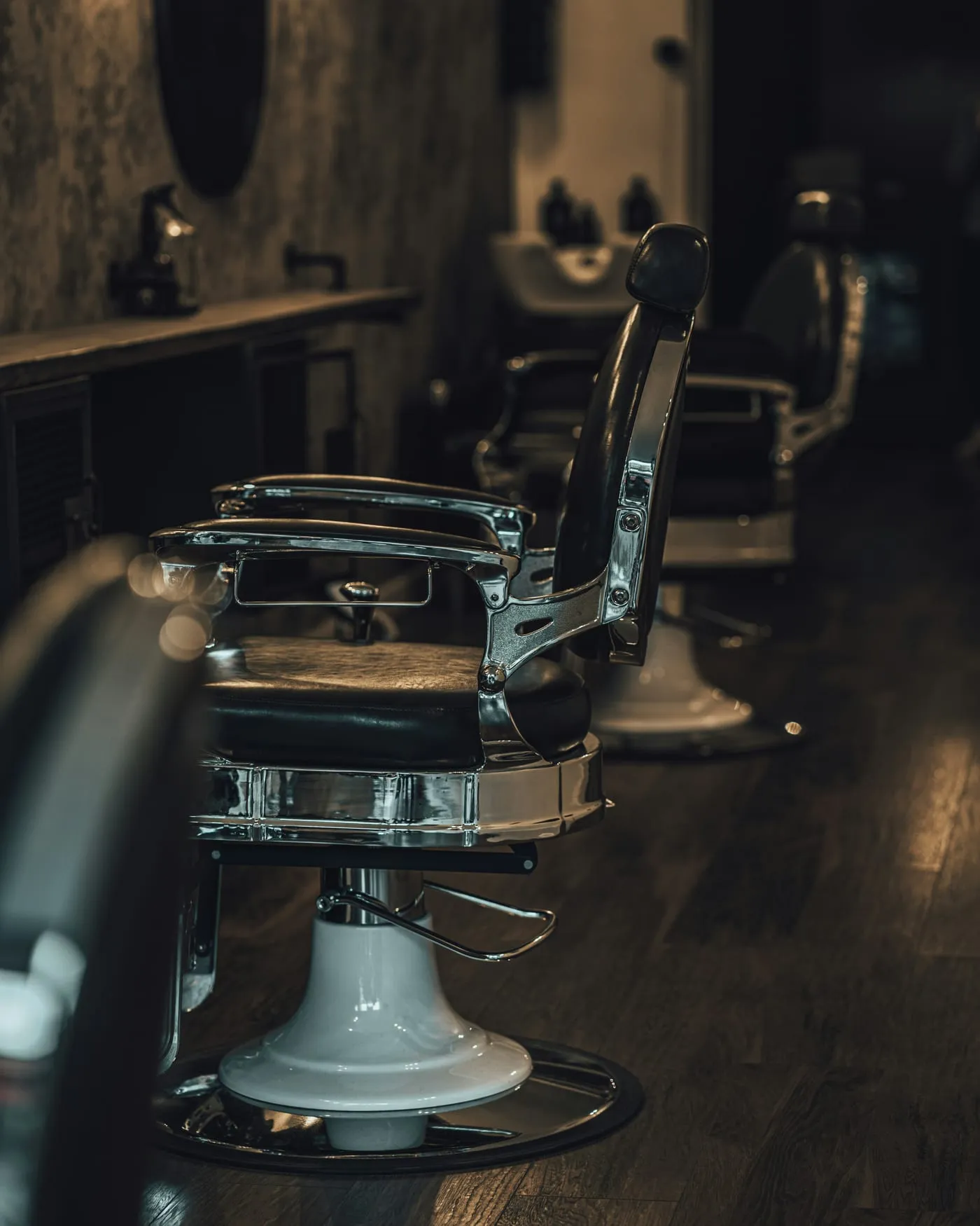 Vintage chrome and leather chairs in a warmly lit barbershop