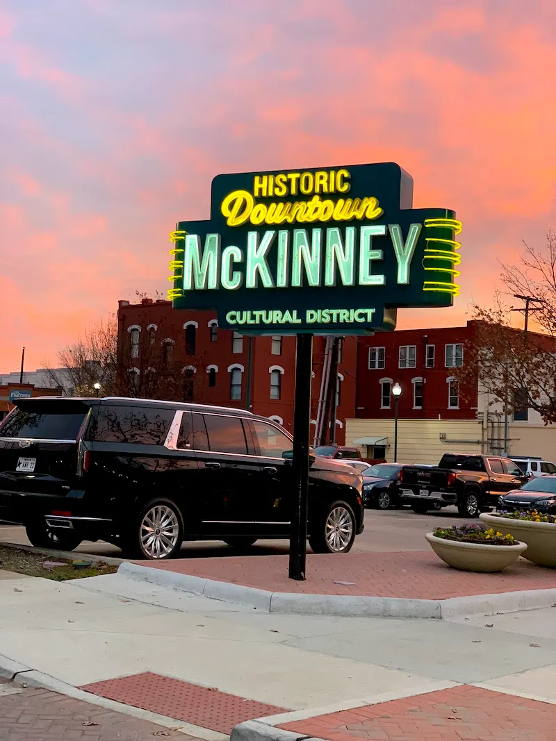 The neon Historic Downtown McKinney sign in the cultural district at dusk